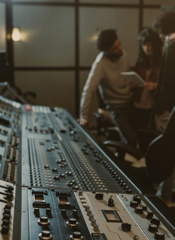 blurred group of musicians spending time at recording studio with graphic equalizer